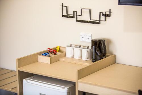 a small kitchen with a counter with cups on it at Nightcap at Blue Cattle Dog Hotel in St Marys