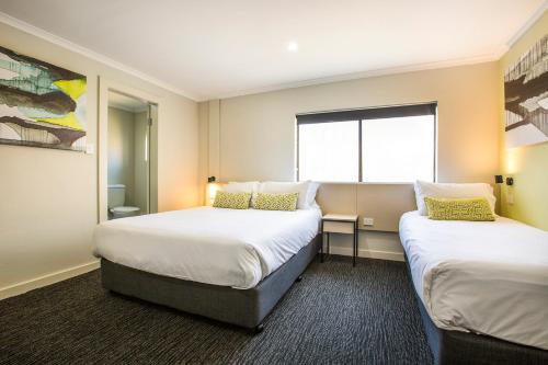 a hotel room with two beds and a window at Nightcap at Blue Cattle Dog Hotel in St Marys