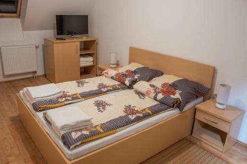 a bedroom with a large bed with a television on it at Sasfészek - Falusi szálláshely in Hortobágy
