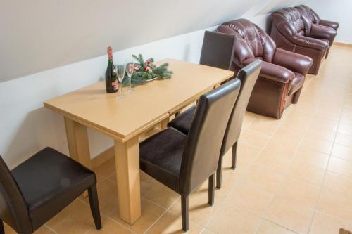 una mesa de comedor con sillas y una botella de champán en Sasfészek - Falusi szálláshely, en Hortobágy
