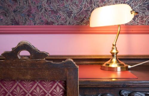 a lamp sitting on a table next to a bed at Hotel Fidder - Patrick's Whisky Bar in Zwolle