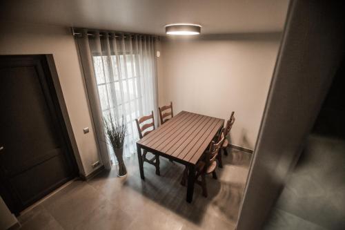 a wooden table and chairs in a room with a window at Villa Buta in Valmiera
