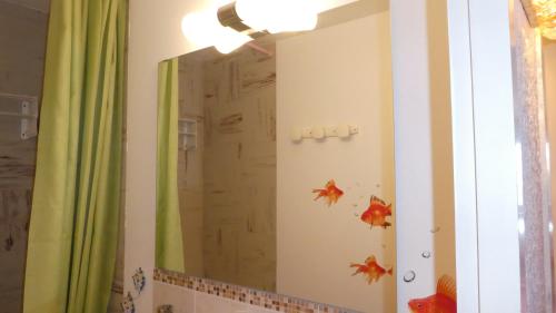 a bathroom mirror with fish decals on the wall at le Vercors en toute simplicite in Autrans