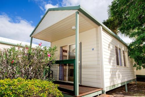 a white and blue house with a wooden roof at Tasman Holiday Parks - Hervey Bay in Hervey Bay