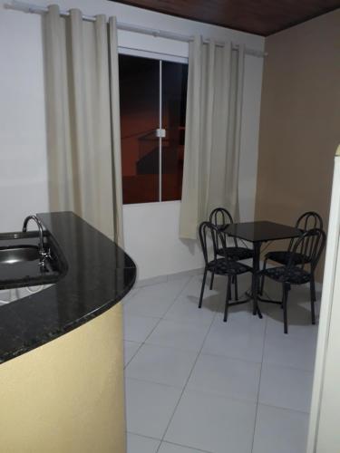 - une cuisine et une salle à manger avec une table et des chaises dans l'établissement Apartamentos em Pipa RN, à Pipa