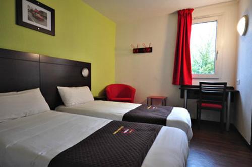 a hotel room with two beds and a desk at Enzo Hotel Mulhouse Sud Morschwiller By Kyriad Direct in Morschwiller-le-Bas
