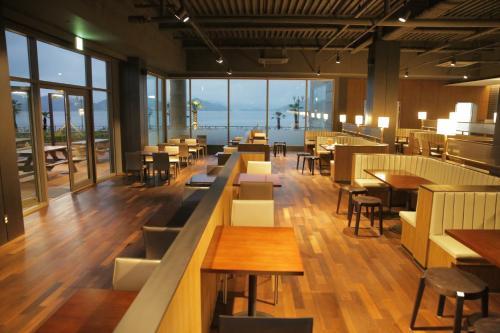 un restaurante con mesas, sillas y ventanas en Kumho Tongyeong Marina Resort en Tongyeong