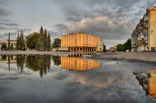 un reflejo de un edificio en un cuerpo de agua en Volyn, en Volodímir-Volinski