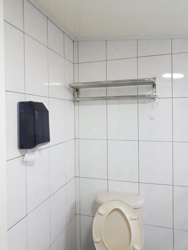 a bathroom with a toilet with a tv on the wall at Fire B&B in Chishang