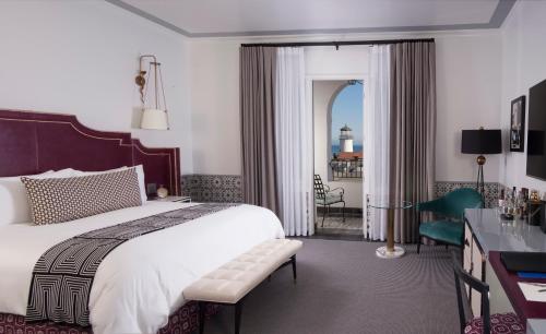 a hotel room with a bed and a desk and a room at Hotel Californian in Santa Barbara