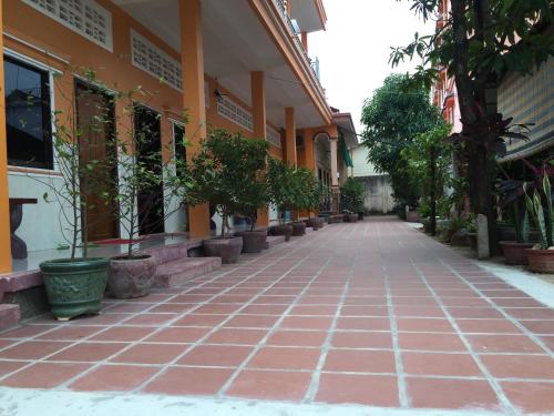 an empty street with potted plants on the side of a building at Ta Eng Guesthouse in Kampot