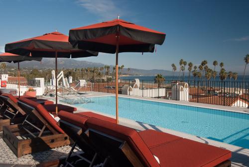 a patio area with chairs, tables and umbrellas at Hotel Californian in Santa Barbara