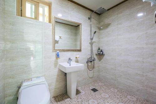 a bathroom with a sink and a toilet and a shower at Mokkoji Pension in Hadong