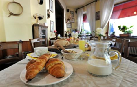 a table with a plate of croissants and a jug of milk at Hotel Etoile De Neige in Valtournenche