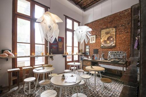 a restaurant with tables and stools in a room with windows at Marcel de Buenos Aires in Buenos Aires