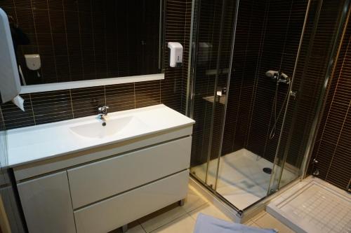 uma casa de banho com um lavatório e um chuveiro em CoolHostel em Porto