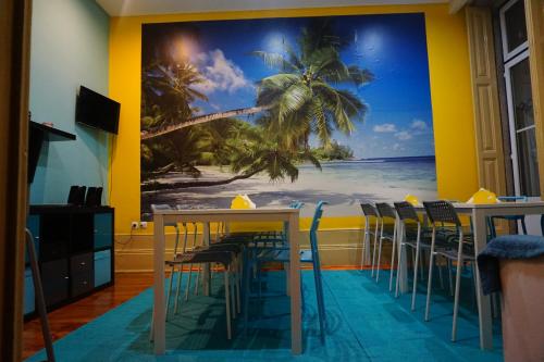 a restaurant with tables and chairs with a palm tree mural at CoolHostel in Porto