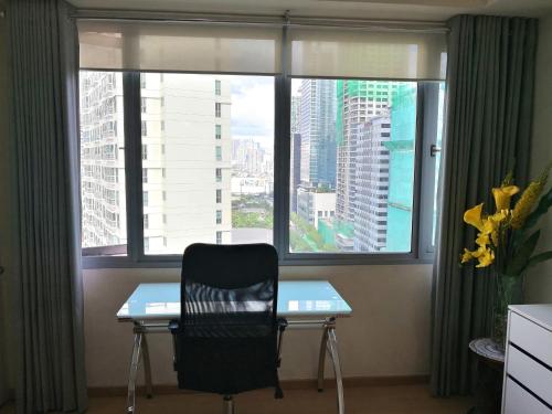 a chair sitting at a desk in front of a window at Avant Apartments at The Fort in Manila