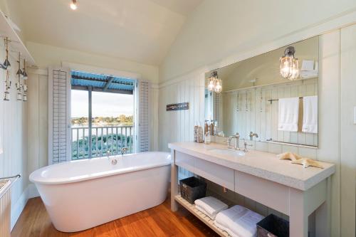 a bathroom with a large tub and a large mirror at Morning Tide in Tauranga