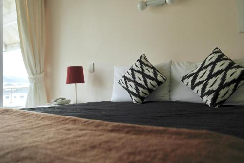 a bedroom with a bed with two pillows and a window at Bucklands Beach Waterfront Motel in Auckland