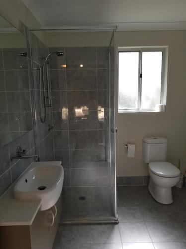 ein Bad mit einer Dusche, einem Waschbecken und einem WC in der Unterkunft Blue on McNab in Katoomba