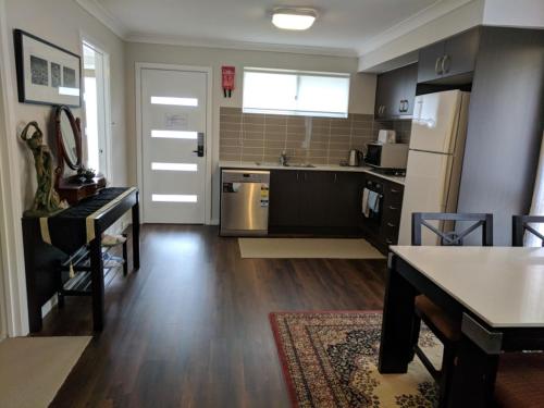 a kitchen with a table and a kitchen with a refrigerator at Blue on McNab in Katoomba