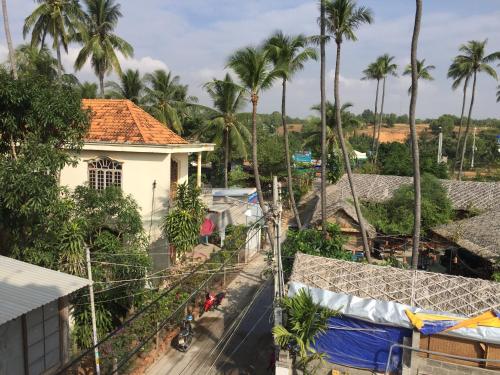 a view from the balcony of a house with palm trees at MAY Bungalow in Mui Ne