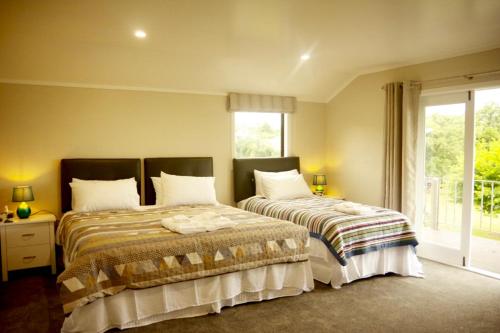 two beds sitting next to each other in a bedroom at Lake Domain Boarding Holiday House in Hamilton