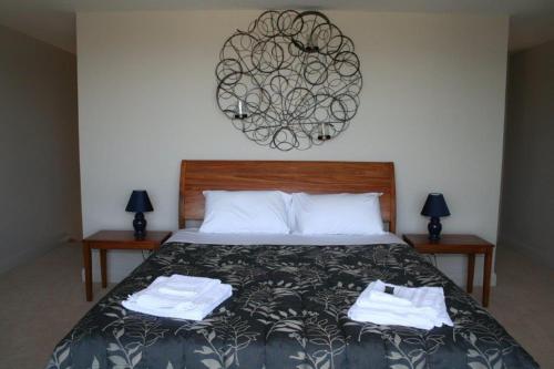 a bedroom with a bed with two towels on it at Leigh Apartments in Leigh