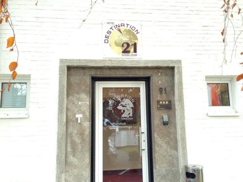 a door to a store with a sign above it at Hotel Destination 21 in Düsseldorf