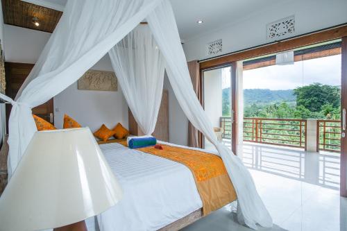 a bedroom with a bed and a large window at Alamdhari Resort and Spa in Sidemen