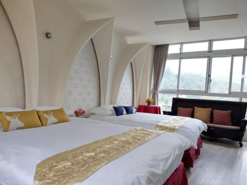 a bedroom with two beds and a large window at Jingxin Yuan Xiang Ju Homestay in Yuchi