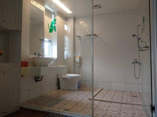 a bathroom with a shower and a toilet and a sink at Jingxin Yuan Xiang Ju Homestay in Yuchi