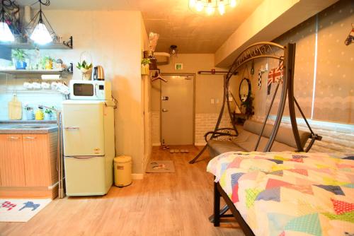 a room with a kitchen and a refrigerator and a bed at Residence Unicorn in Seoul