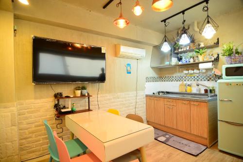 a kitchen with a table and a tv on the wall at Residence Unicorn in Seoul