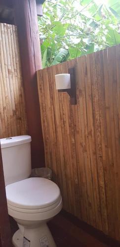 a bathroom with a toilet and a wooden fence at Namkat Yorla Pa Resort in Ban Kat