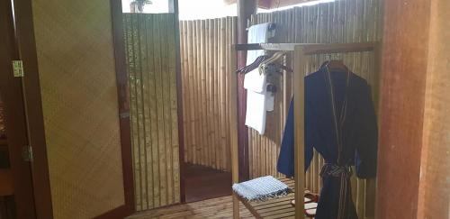 a room with a mirror and a chair and a robe at Namkat Yorla Pa Resort in Ban Kat