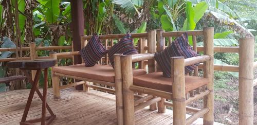 a wooden chair sitting on a wooden deck at Namkat Yorla Pa Resort in Ban Kat