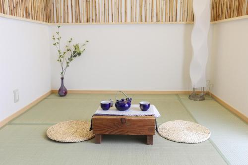 a living room with a table and two stools at Lucy's House 横浜中華街 House2 in Yokohama
