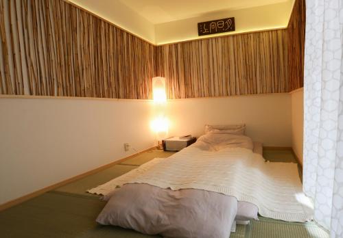 a bedroom with a bed with a sign on the wall at Lucy's House横浜中華街 House2 in Yokohama