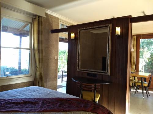Wandering的住宿－Hotham Ridge Estate，一间卧室配有一张床、一台电视和一张桌子