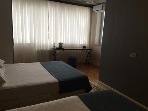 a room with two beds and a table with a window at Baku Sea View Hotel in Baku