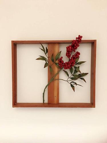 a wooden frame with a flower on a wall at Lucy's House横浜中華街 House3 in Yokohama
