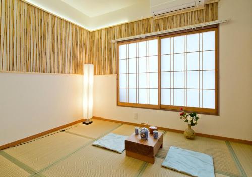 Zimmer mit einem Tisch und einem großen Fenster in der Unterkunft Lucy's House横浜中華街 House3 in Yokohama