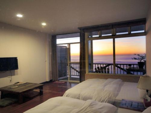 a bedroom with a bed and a view of the ocean at Sky lounge B&B in Zhushan