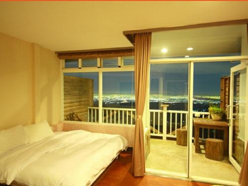 a bedroom with a bed and a large window at Sky lounge B&B in Zhushan