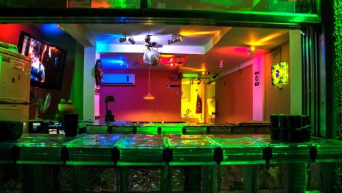 - un bar avec des lumières vertes et roses dans une pièce dans l'établissement Tupiniquim Hostel Rio de Janeiro, à Rio de Janeiro
