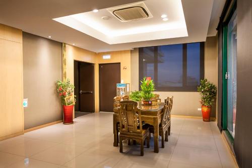 a dining room with a table and chairs and plants at 雲林商旅 in Tuku
