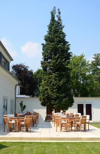 a group of tables and chairs next to a tree at Hotel Destination 21 in Düsseldorf
