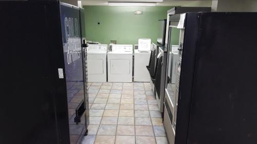 lavadero con electrodomésticos blancos y suelo de baldosa en Mentor Home Inn and Suites, en Mentor